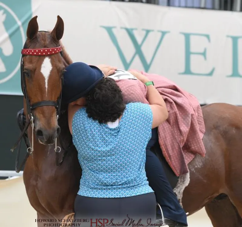 Trainer gives rider a hug after finishing her class